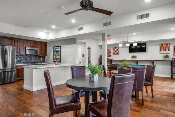 Interior view of a recreational area with a kitchen and seating areas.