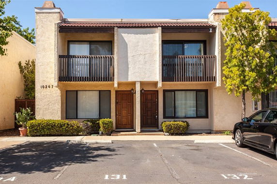 Front view of a two-story building with balconies and two entrance doors.