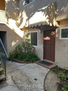 Front view of a building entrance with a brown door and a small awning.
