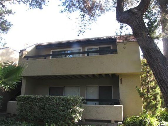 Front view of a two-story house with balcony and large windows.
