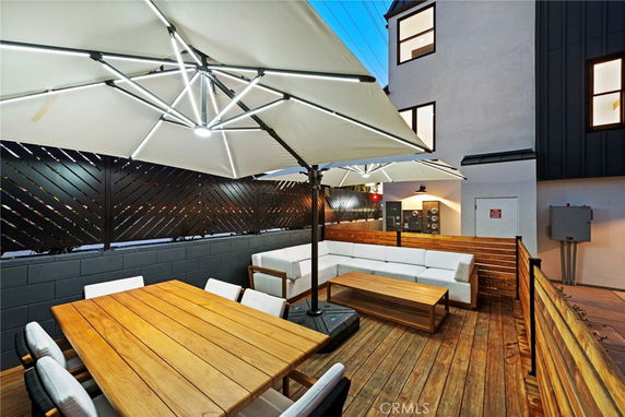 Outdoor rooftop area with seating and large umbrellas.