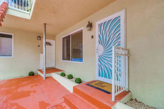 Front view of a building entrance with decorative door and porch area.