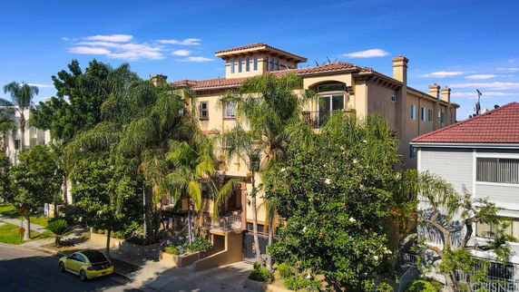 Front view of a multi-story building with a Spanish-style roof and multiple balconies.