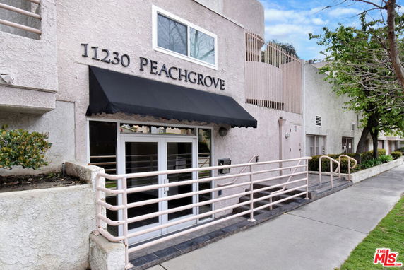 Front view of a building with an entrance and signage displaying '11230 Peachgrove'.