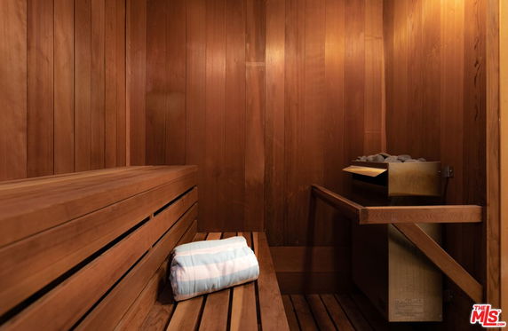 Interior view of a wooden sauna with benches and heater.