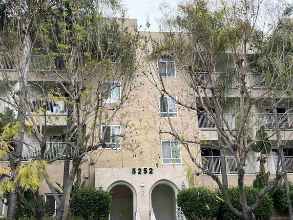 Front view of a multi-story apartment building with balconies.