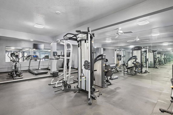 Indoor gym area with exercise equipment and mirrors.