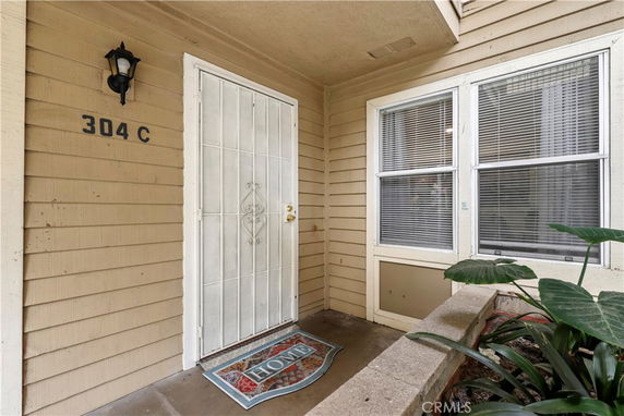 Front view of a house entrance with a security door and a welcome mat.
