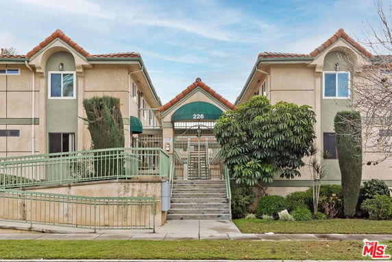 Front view of a two-story building with an entrance and green awnings.