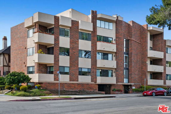 Front view of a multi-story apartment building with brick and concrete facade.