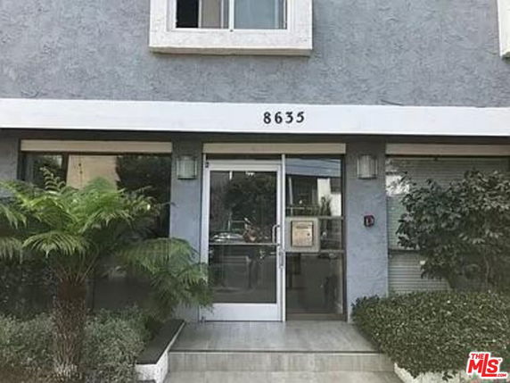 Front view of a building with a glass entrance door and the number 8635 displayed above.