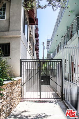Front view of a multi-story building with gated entrance.