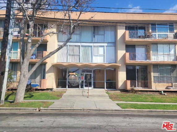 Front view of a multi-story apartment building with balconies.
