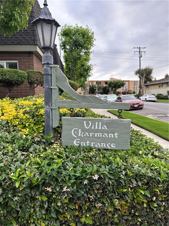 Front view of a building with a sign reading 'Villa Charmant Entrance' and a brick facade.