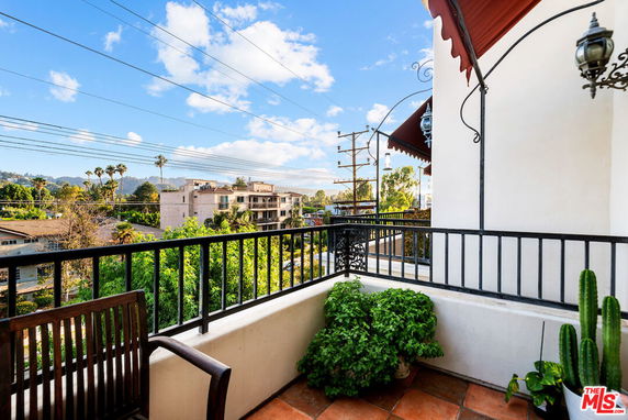 Balcony view overlooking buildings and landscape in the distance.