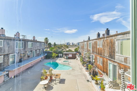 View of a swimming pool between two apartment buildings.