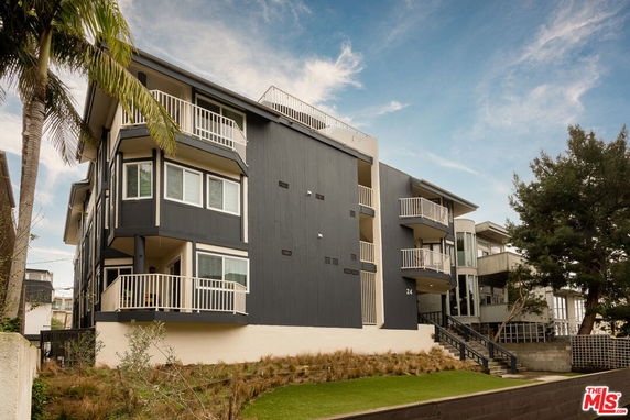 Front view of a multi-story building with several balconies and a modern design.