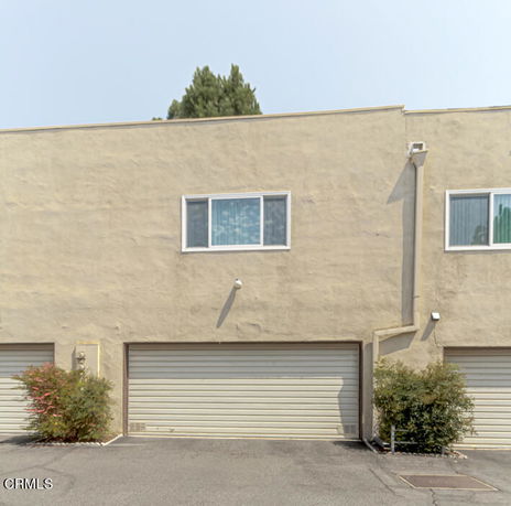 Front view of a building with two garage doors and windows above.