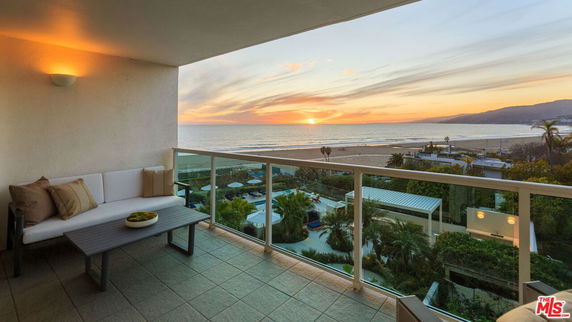 Balcony view of ocean and sunset from a building.