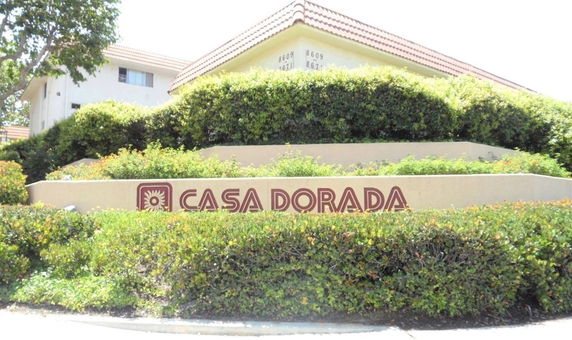 Front view of a building with a sign reading 'Casa Dorada' surrounded by greenery.