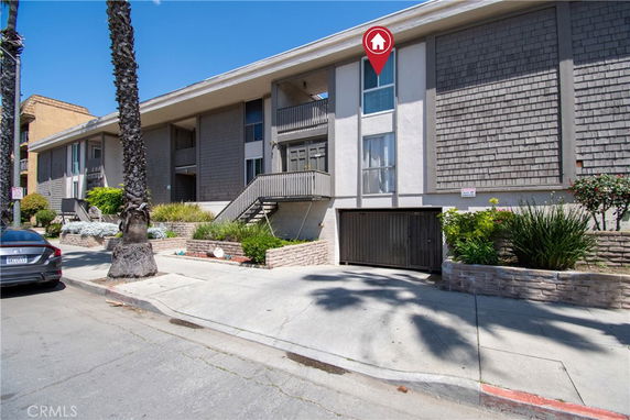 Front view of a multi-story building with balconies and a garage entrance.