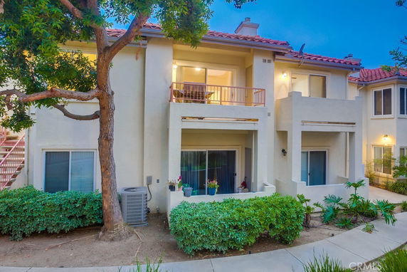 Front view of a two-story residential building with balconies and large windows.