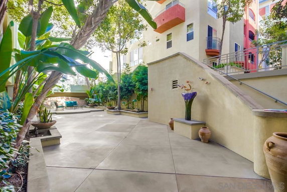 Outdoor courtyard area with plants and seating in front of a building.