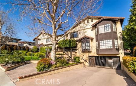 Front view of a multi-story house with a garage entrance and landscaped driveway.