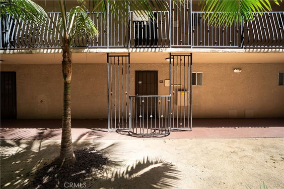 Front view of a building with a gated entrance and balcony.