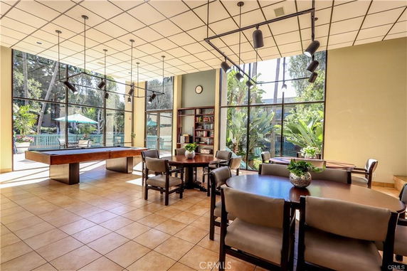 Interior of a clubhouse with tables, chairs, and a pool table.