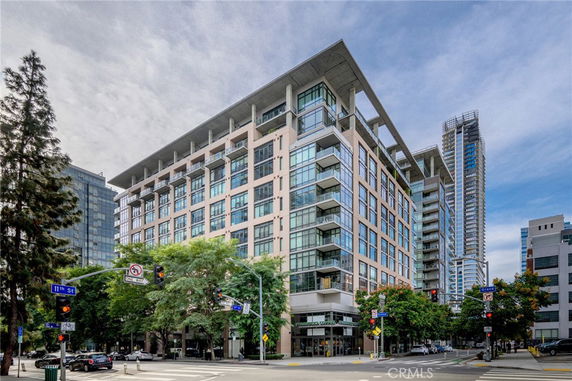 Front view of a modern multi-story building at an intersection.