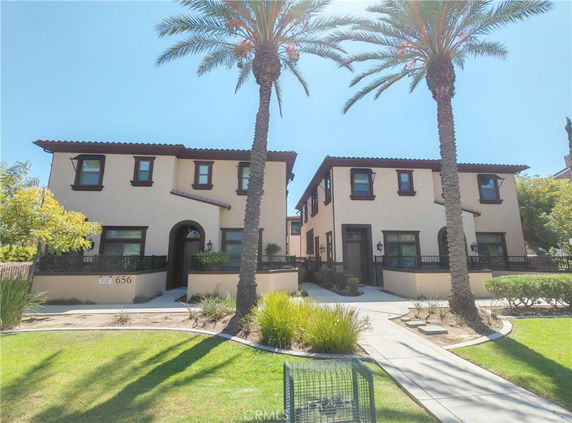 Front view of two-story buildings with tile roofs and arched entries