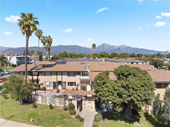 Front view of a two-story residential building with solar panels on the roof.