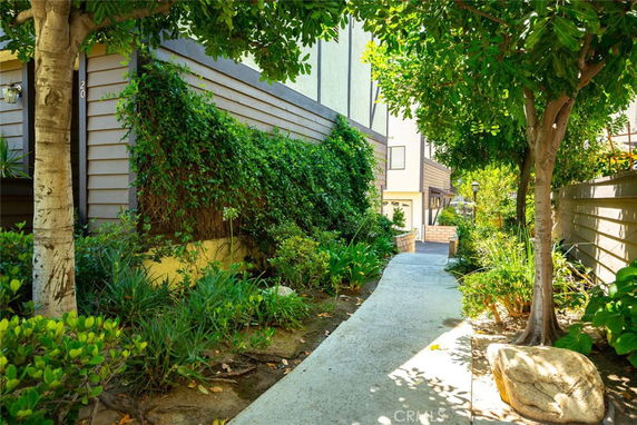 Front view of a residential building with a walkway and greenery.