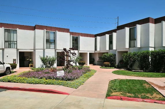 Front view of a modern two-story building with large windows and a garden.