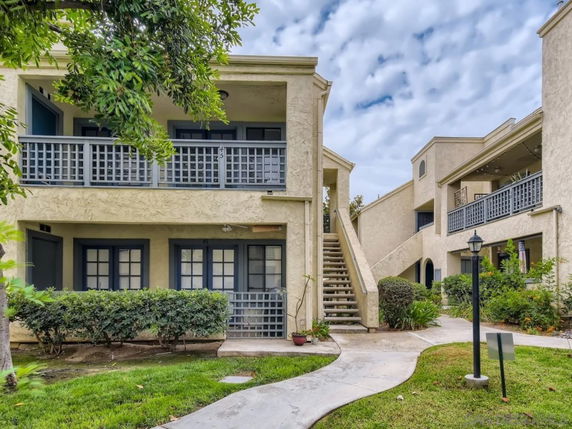 Front view of a two-story apartment building with exterior stairs.