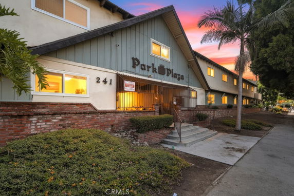 Front view of a building with a peaked roof and a gated entrance, labeled Park Plaza.