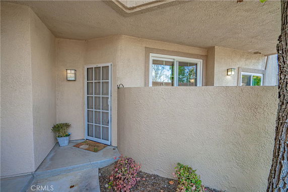 Front view of a house entrance with a white door and adjacent window.