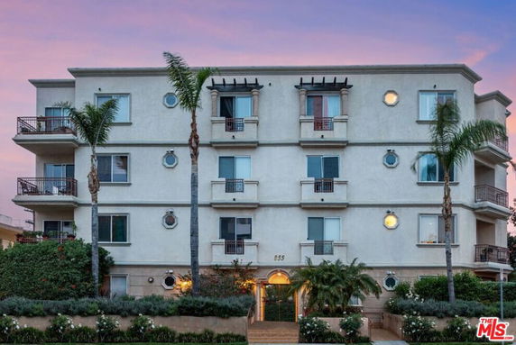Front view of a multi-story apartment building with balconies.
