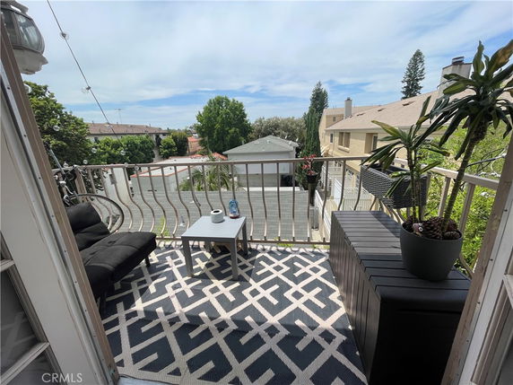View from a balcony showing rooftops and trees.