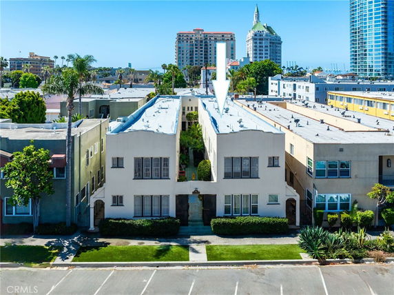 Front view of a multi-story residential building with flat roof and large windows.