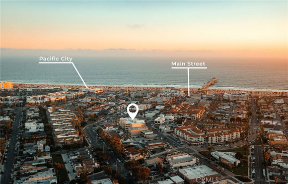 Wide-angle view of a coastal city with ocean in the background and labeled landmarks.