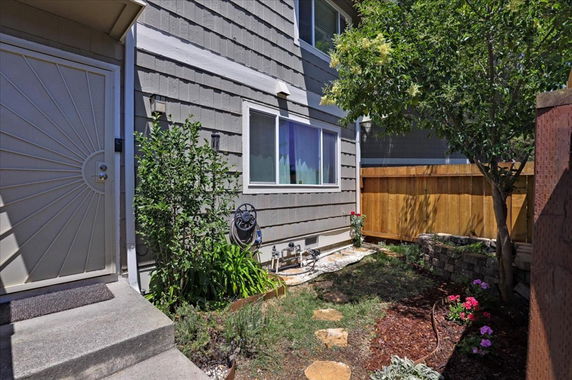 Side view of a house with shingle siding and a pathway leading to the entrance.