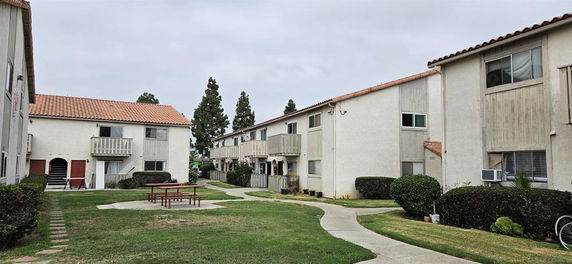 View of residential apartment buildings with balconies and pathway.