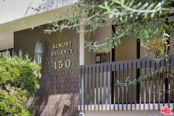 Front view of a building with a name and number displayed on a wall.