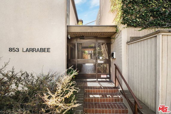 Front view of a building entrance with stairs and a gate.