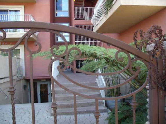 Front view of a multi-story building with balconies and ornamental gate.