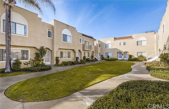 Front view of a two-story building with beige stucco exterior and decorative arches.
