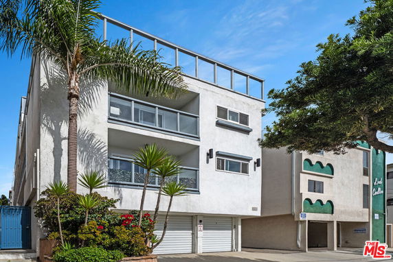 Front view of a multi-story building with a modern design and balconies.