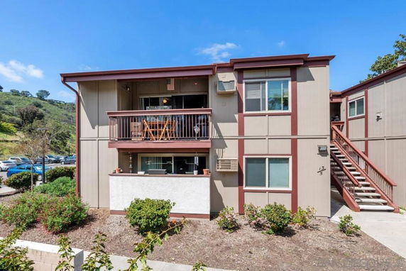 Front view of a two-story residential building with balconies and external staircases.